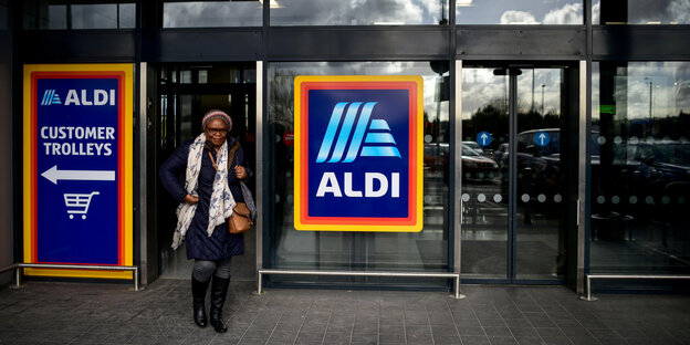 Eine Frau verlässt einen Aldi-Supermarkt