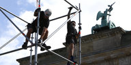 Männer bauen ein Gerüst vor dem Brandenburger Tor auf