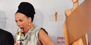 Katja Riemann steckt den Filmpreis Lola fast in den Mund