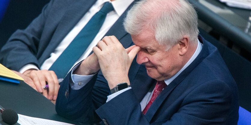 Horst Seehofer stützt genervt den Kopf in seine Hände