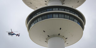 Ein Hubschrauber fliegt neben dem Hamburger Fernsehturm.