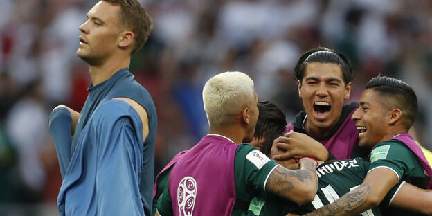 Manuel Neuer steht enttäuscht neben der jubelnden mexikanischen Mannschaft