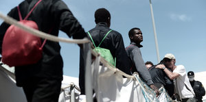Männer verlassen das Schiff Aquarius im Hafen, einer wird zur Begrüßung umarmt