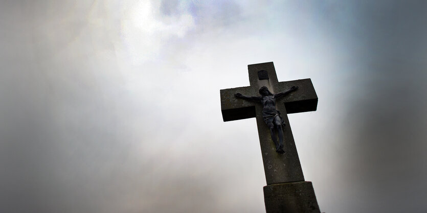 Ein Kreuz, dahinter dunkle Wolken