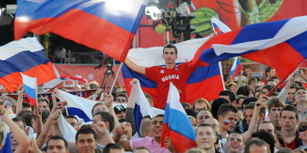 Russischer Fan mit Fahne in der Menge