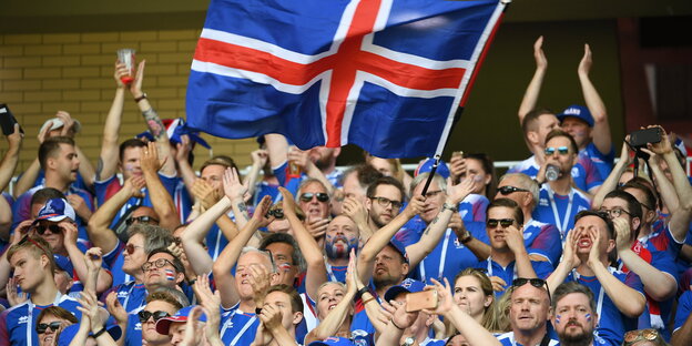 Jubelnde Menschen mit einer isländischen Fahne