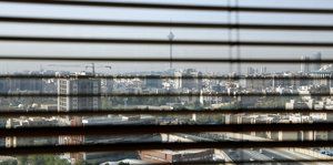 Die Skyline der Stadt Teheran durch die Jalousie vor einem Fenster
