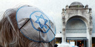 Closeup auf Demonstrierende vor einer Synagoge, die Kippa trägt