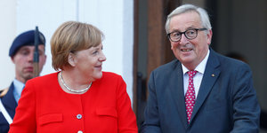 Merkel lächelt EU-Kommissionschef Jean-Claude Juncker an