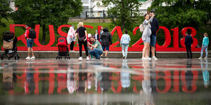 Passanten in Jekaterinburg machen Fotos vor dem WM-Schriftzug