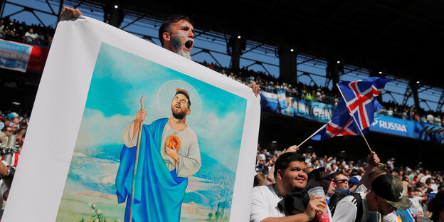 Fans halten ein Plakat, auf dem Messi als Heiliger abgebildet ist