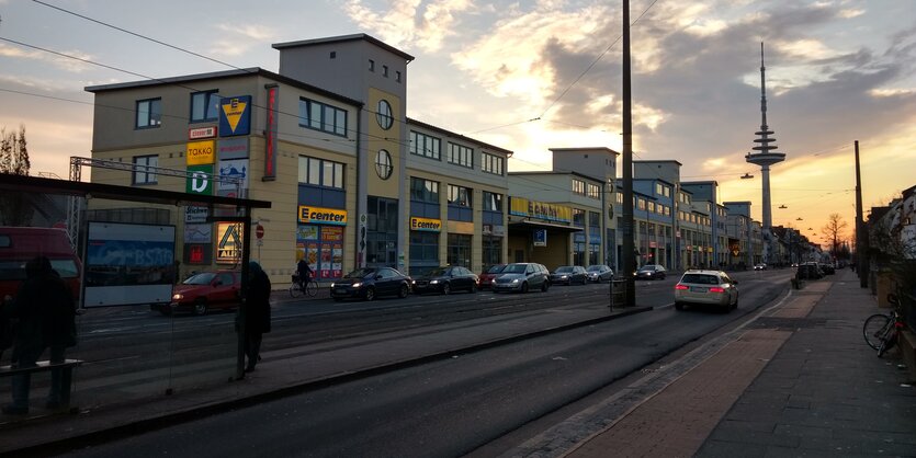 Straßenbahnschienen zwischen Autofahrspuren, dahinter ein Sonnenuntergang