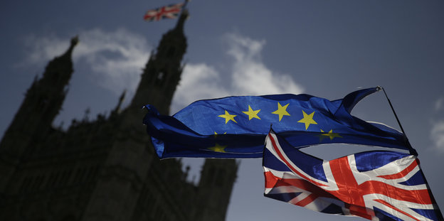 Eine EU-Flagge und eine britische Nationalflagge wehen vor dem britischen Parlament