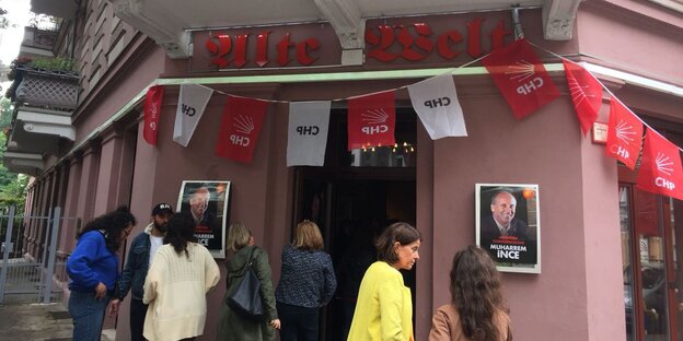 Menschen an einer Hausecke, dort ist ein Eingang, über dem "Alte Welt" steht, an der Wand hängen Fähnchen mit der Aufschrift "CHP" Menschen an einer Hausecke, dort ist ein Eingang, über dem "Alte Welt" steht, an der Wand hängen Fähnchen mit der Aufschrift "CHP"