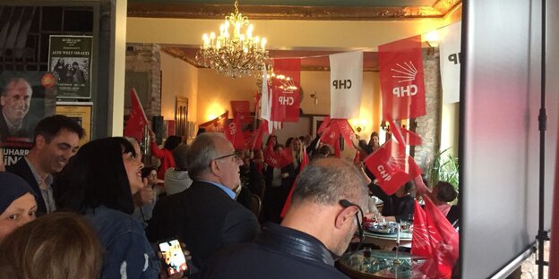 CHP-Wahlversammlung in Berlin-Neukölln: Menschen in einem Raum, Wimpel mit "CHP"-Aufschrift hängen von der Decke CHP-Wahlversammlung in Berlin-Neukölln: Menschen in einem Raum, Wimpel mit "CHP"-Aufschrift hängen von der Decke
