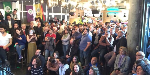 viele Menschen, über ihnen Diskokugeln, an der Wand viele Menschen, über ihnen Diskokugeln, an der Wand