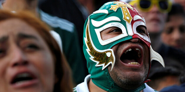 Ein mexikanischer Fan mit Fan-Maske jubelt in Mexiko City.
