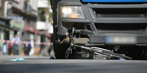 Ein stark beschädigtes Fahrrad liegt unter einem Lastwagen