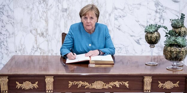 Bundeskanzlerin Angela Merkel trägt einen Blumenstrauß. im Kanzleramt