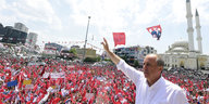 Muharrem Ince, wie er den Arm hebt vor einer Menschenmasse mit Türkei-Flaggen und Transparenten