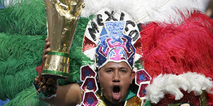 Ein folkloristisch verkleider Mexiko-Fan mit einer Pokalattrappe