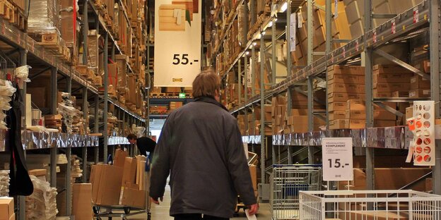 Ein Mann vor langen Ikea-Regalreihen