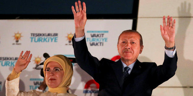 Erdoğan und seine Frau, wie sie die Hände hochheben
