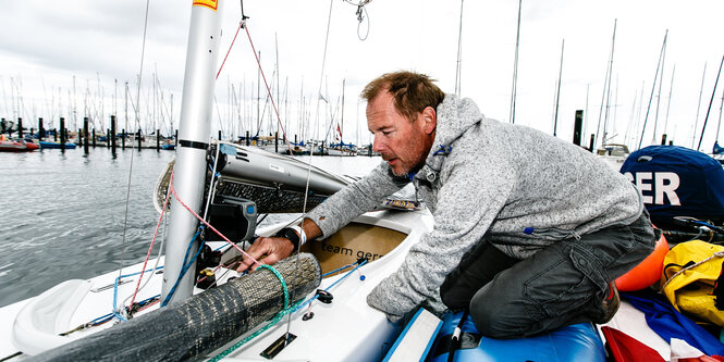 Heiko Kröger prüft auf seinem Segelboot die Leinen