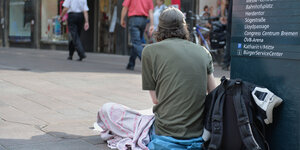 Ein Obdachloser sitzt auf dem Boden