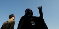 Lord Darth Vader als Standdenkmal, ein Mann steht daneben und sieht zu Darth Vader auf