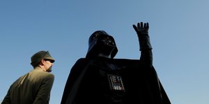 Lord Darth Vader als Standdenkmal, ein Mann steht daneben und sieht zu Darth Vader auf