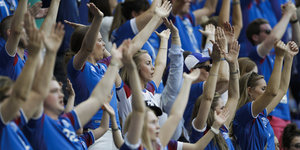 Isländische Fans strecken die Arme in die Höhe, um ihre Mannschaft anzufeuern.