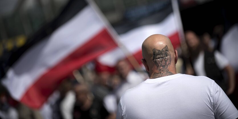 Ein Mann mit Wolfstattoo auf dem Hinterkopf bei einer rechtsextremen Demo