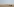 Blick über eine Wüstenlandschaft - im Vordergrund laufen Menschen, im Hintergrund das Skelett eines unfertigen Gebäudes