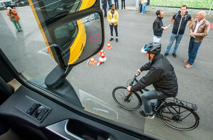 Blick durch ein Lastwagenfenster auf einen Radfahrer im Toten Winkel Blick durch ein Lastwagenfenster auf einen Radfahrer im Toten Winkel