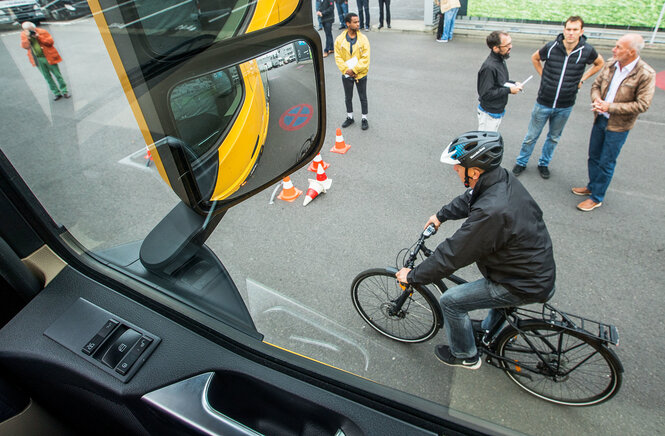 Blick durch ein Lastwagenfenster auf einen Radfahrer im Toten Winkel