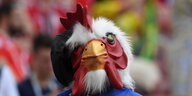 ein Fan in französischen Nationalfarben mit einer Hühnerkopfmaske