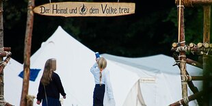 Ein Zeltplatz mit einer Eingangspforte. Darauf steht "Der Heimat und dem Volke treu"