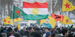 Eine Demonstration mit einer Fahne, die Abdullah Öcalan zeigt