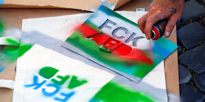 Eine Schablone in Rot, Blau und Grün, mit der sich die Buchstaben FCK AFD drucken lassen