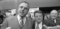 Helmut Kohl und Franz-Josef Strauß stehen im Anzug mit Krawatte nebeneinander, zu ihnen wird ein Mikrofon gehalten