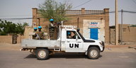 In einem mit dem Schriftzug "UN" versehenen Fahrzeug sitzen und stehen uniformierte Soldaten mit blauen Helmen