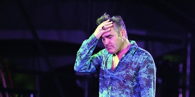 Morrissey auf der Bühne - er fasst sich an die Stirn