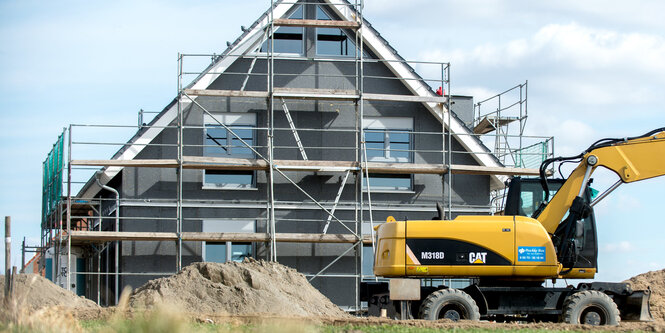 Ein Bagger vor einem Haus