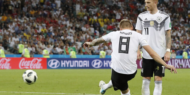 Toni Kroos schießt einen Fußball, ein anderer deutscher Spieler steht neben ihm Toni Kroos schießt einen Fußball, ein anderer deutscher Spieler steht neben ihm