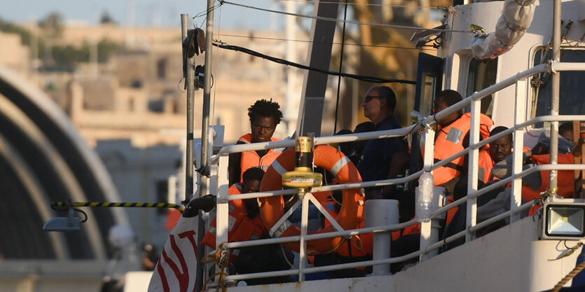 Menschen warten auf einem Schiff, das in einem Hafen liegt