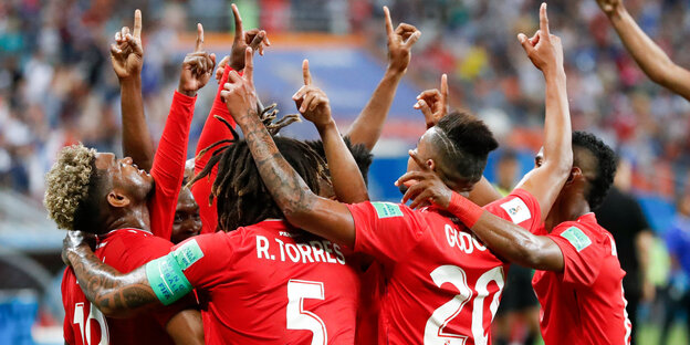 Spieler von Panama stehen sich umarmend auf dem Platz und zeigen mit den Zeigefingern gen Himmel