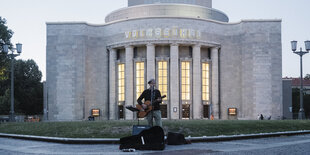 Straßenmusiker steht vor der Volksbühne