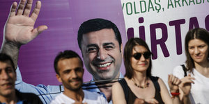 Menschen vor einem Plakat, das Selahattin Demirtas zeigt