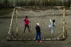 Kinder spielen an einem kaputten Fußballtor